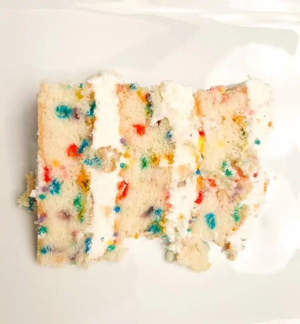 http://www.mealfinds.com/wp-content/uploads/2022/01/milk-bar-vanilla-6-inch-birthday-cake-slice-milk-bar-birthday-cake-review-mealfinds.jpg.webp