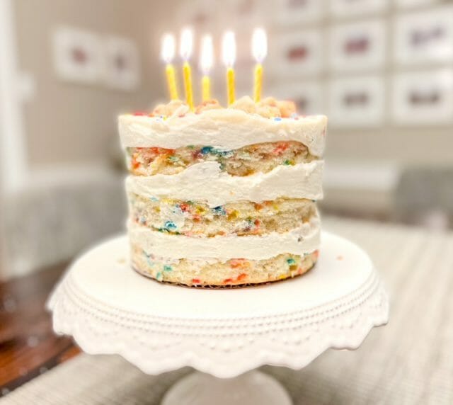 http://www.mealfinds.com/wp-content/uploads/2022/01/milk-bar-vanilla-birthday-cake-with-lit-candles-milk-bar-birthday-cake-review-mealfinds.jpg